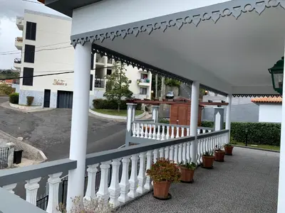 a white porch with potted plants on it at Funchal Apt- Sleeps 2 - Pool & Parking - Madeira in Funchal