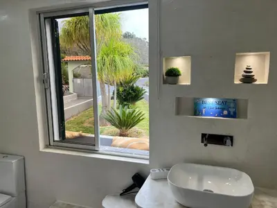 a bathroom with a white sink and a window at Villa do Monte in Porto Moniz