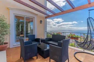 a balcony with chairs and a view of the ocean at Villa Bougainvillea Palheiro Village by Holiday Rental Madeira in Funchal
