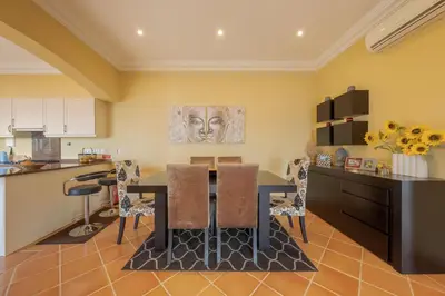 a kitchen and dining room with a table and chairs at Villa Bougainvillea Palheiro Village by Holiday Rental Madeira in Funchal