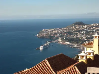 a view of a city with a boat in the water at Villa Bougainvillea Palheiro Village by Holiday Rental Madeira in Funchal