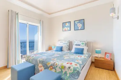 a bedroom with a bed and a large window at Villa Bougainvillea Palheiro Village by Holiday Rental Madeira in Funchal
