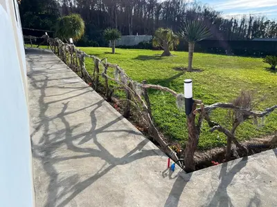 a yard with a house and a fence at VM Sunset in Porto Moniz