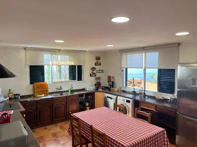 a kitchen with a table with a red and white checkered table cloth at VM Sunset in Porto Moniz