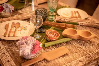 a table with wooden spoons and plates and wine glasses at Villa - Cantinho do Paraíso in Santo Espírito