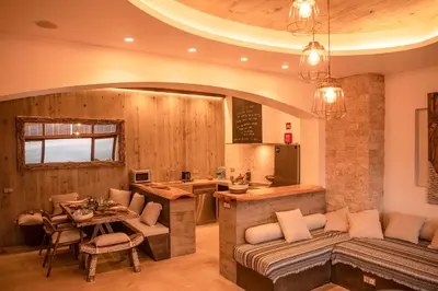 a kitchen and living room with a couch and a table at Villa - Cantinho do Paraíso in Santo Espírito