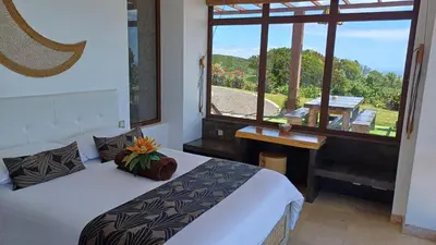 a bathroom with a window and a plant in a shower at Villa - Cantinho do Paraíso in Santo Espírito