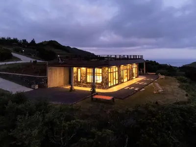 a house on a hill with a view of the ocean at Villa - Cantinho do Paraíso in Santo Espírito