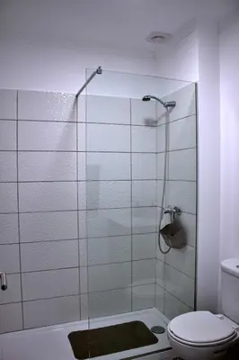a bathroom with a glass shower with a toilet at Apartamento DAVI in Funchal
