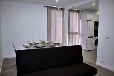 a dining room table with a black chair in a room at Apartamento DAVI in Funchal