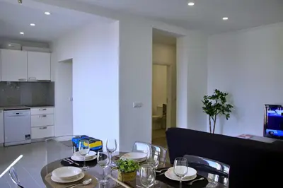 a dining room with a table and chairs and a kitchen at Apartamento DAVI in Funchal