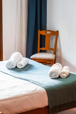 three towels on a bed with a chair in a room at Camoes Apartment by Atlantic Holiday in Funchal