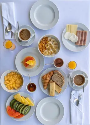 a table with plates of food and cups of coffee at Quinta Vale Vitis in São Vicente