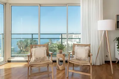 a living room with two chairs and a floor to ceiling windows at Rodamar II by An Island Apart in Funchal