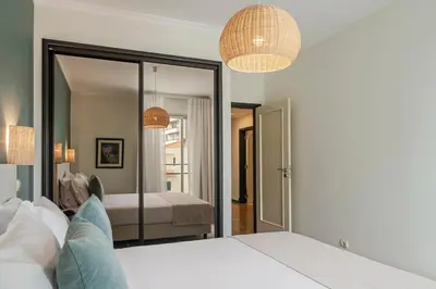 a bedroom with a bed and a mirror at Rodamar II by An Island Apart in Funchal