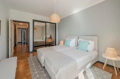 a bedroom with a large white bed with blue pillows at Rodamar II by An Island Apart in Funchal