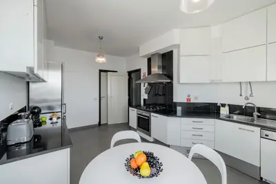a kitchen with white cabinets and a table with fruit on it at Rodamar II by An Island Apart in Funchal