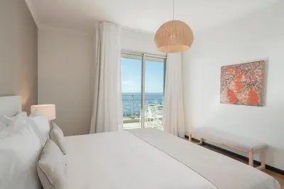 a white bedroom with a large bed and a window at Rodamar II by An Island Apart in Funchal