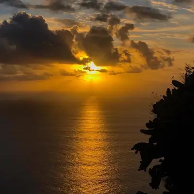 a sunset over the ocean with the sun in the sky at Sol & Mar Rancho in Câmara de Lobos