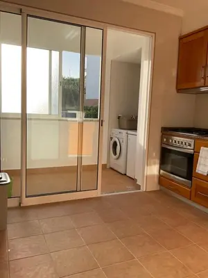 a kitchen with sliding glass doors and a washer and dryer at Sol & Mar Rancho in Câmara de Lobos