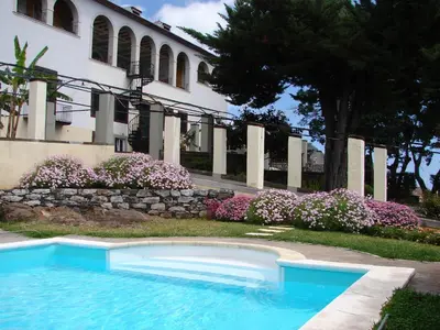 a swimming pool in front of a building with flowers at Private Pool Apt. with Great View in Funchal