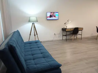 a living room with a blue couch and a piano at Tanoeiros Studios in Funchal