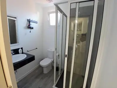 a bathroom with a toilet and a glass shower at Tanoeiros Studios in Funchal