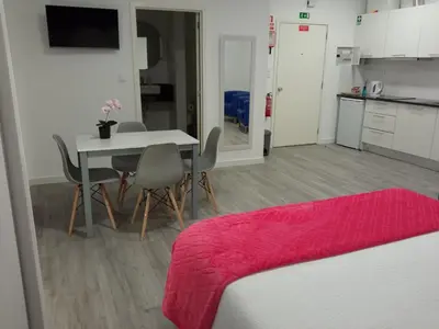 a room with a table and chairs and a kitchen at Tanoeiros Studios in Funchal