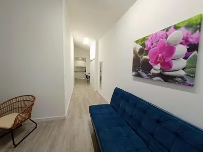 a living room with a blue couch and a painting on the wall at Tanoeiros Studios in Funchal