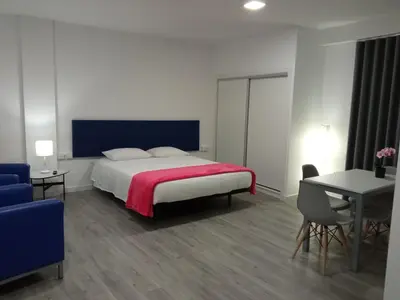 a bedroom with a bed and a table and chairs at Tanoeiros Studios in Funchal