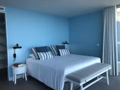 a blue bedroom with a large bed with a bench at Casa Del Mar- Wonderfull Sea Views & Swimming Pool in Ponta Delgada