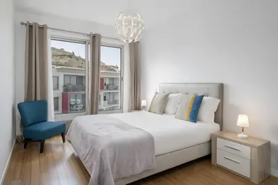 a bedroom with a white bed and a blue chair at Amparo Delight by Homie in Funchal