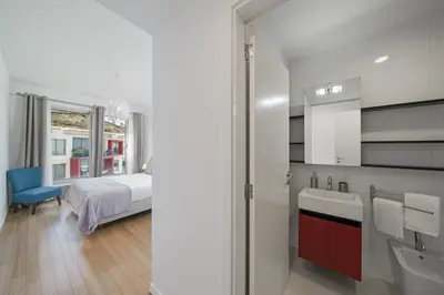 a bathroom with a sink and a bedroom with a bed at Amparo Delight by Homie in Funchal