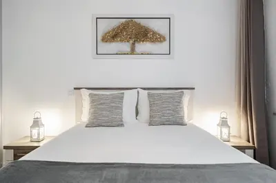 a bedroom with a white bed with a tree above it at Amparo Delight by Homie in Funchal