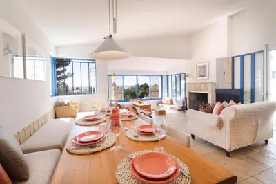 a living room with a table and chairs and a couch at Casa do Barco in Luz