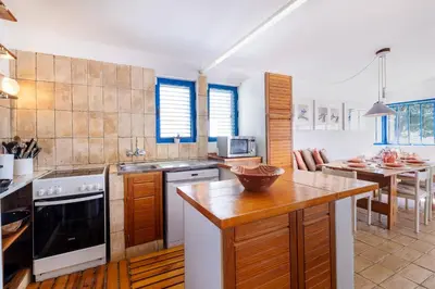 a kitchen with a table and a counter top at Casa do Barco in Luz