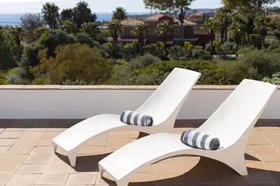 two white chairs sitting on top of a patio at Casa do Barco in Luz