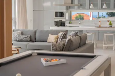 a living room with a couch and a kitchen at OurMadeira - Ocean Panorama in Estreito da Calheta