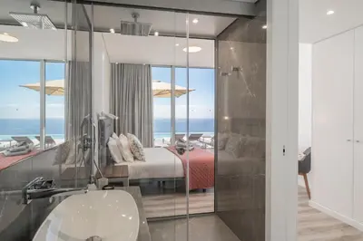 a bathroom with a bed and a glass shower at OurMadeira - Ocean Panorama in Estreito da Calheta