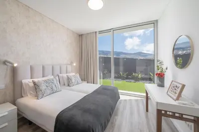 a bedroom with a bed and a large window at OurMadeira - Ocean Panorama in Estreito da Calheta