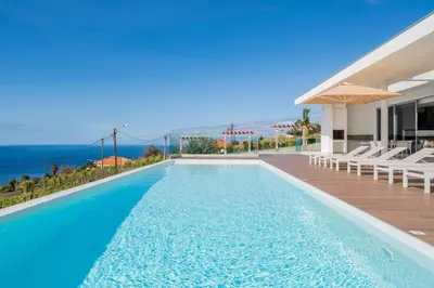 a swimming pool with a view of the ocean at OurMadeira - Ocean Panorama in Estreito da Calheta