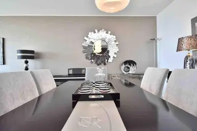 a dining room with a table with chairs and a mirror at Rubeus in Caniço