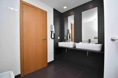 a bathroom with two sinks and two mirrors at Rubeus in Caniço