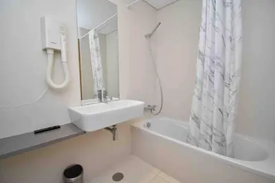a white bathroom with a sink and a bath tub at Rubeus in Caniço