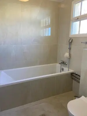 a bathroom with a white tub and a toilet at VILLA LEONARDO in Caniço