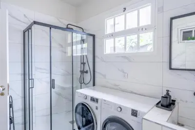 a white laundry room with a washer and dryer at VILLA LEONARDO in Caniço