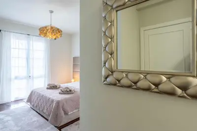 a bedroom with a bed and a mirror on the wall at VILLA LEONARDO in Caniço