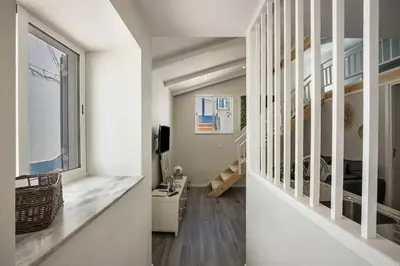 a living room with a large window and a bedroom at Casa da Villa in Vila do Bispo