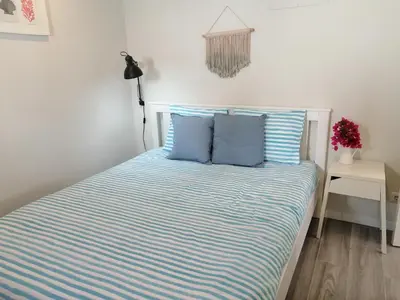 a bed with two blue pillows in a bedroom at Casa da Villa in Vila do Bispo