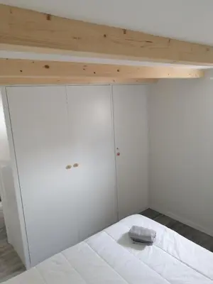 a bedroom with white cabinets and a white bed at Casa da Villa in Vila do Bispo
